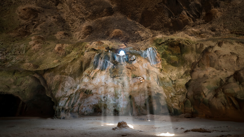 Quadirikiri Cave in Aruba with natural light filtering through its limestone windows.
