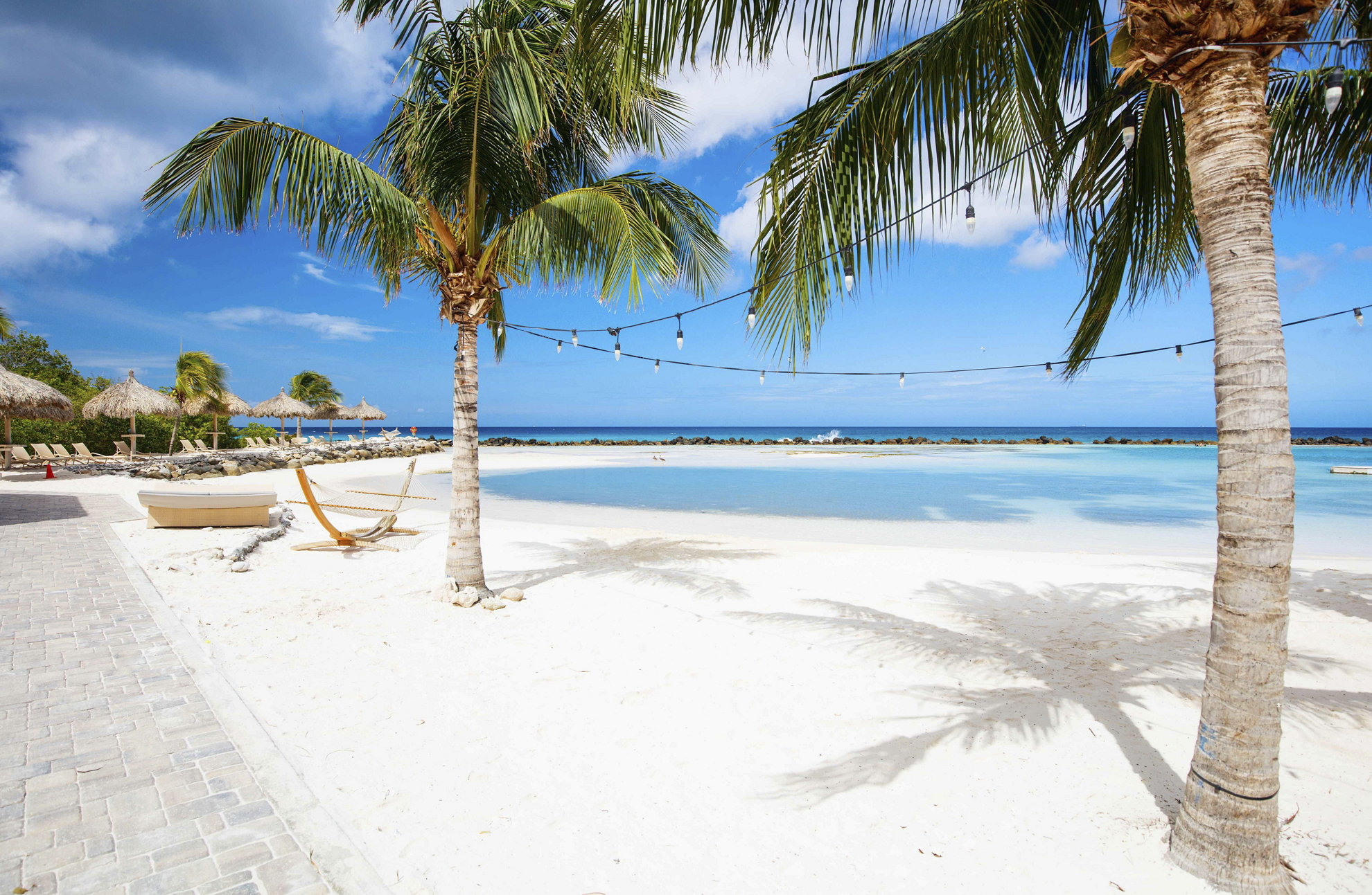 Schneeweißer Sandstrand mit Palmen auf Aruba