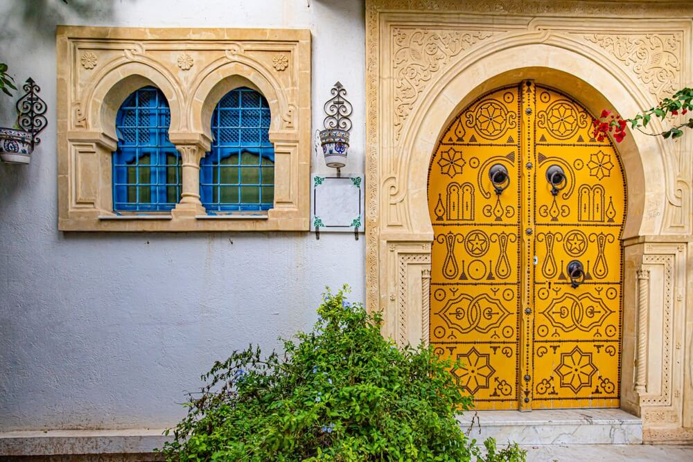 Attractions in Sousse: a decorated wooden doorway flanked by painted windows in Sousse medina