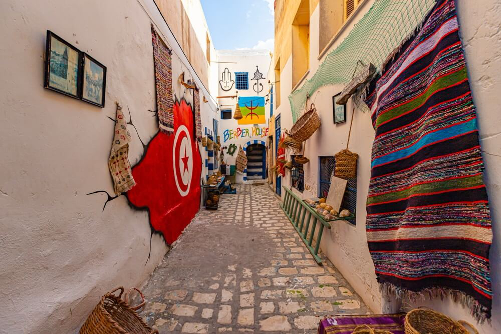 Attractions in Sousse: a shop displays handwoven carpets and baskets in an alley in Sousse medina 