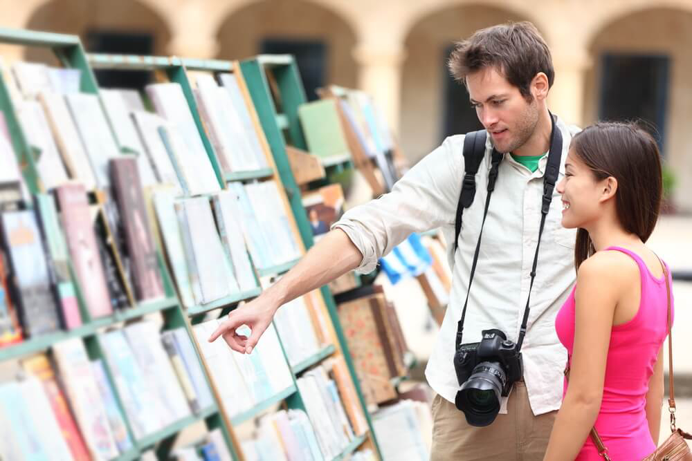 Tourists looking at books displayed outdoors in Spain