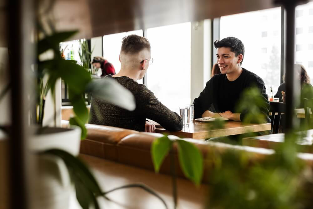 Two young men chatting in a bar