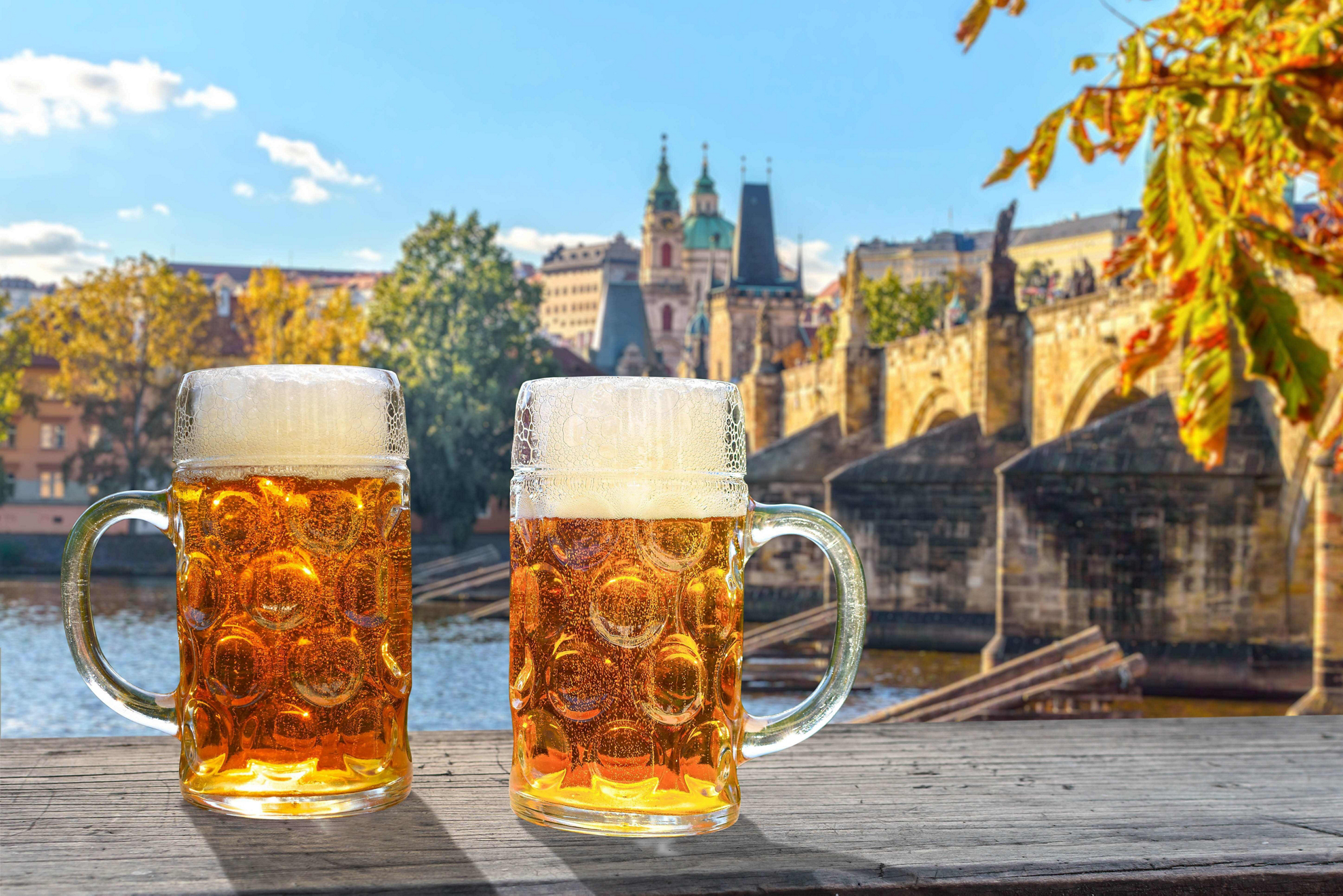 Beer in Prague: Two foamy beers by the river and a bridge in Prague