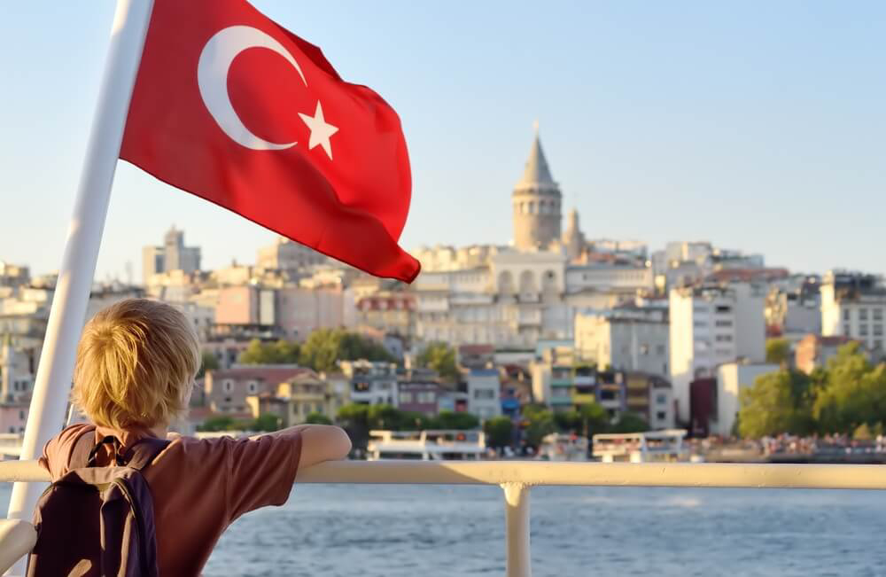 A child takes in the Istanbul skyline from a riverboat