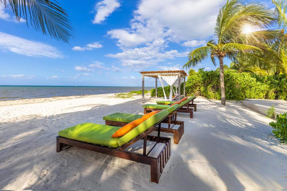 Best islands for a honeymoon: Two sun loungers on a white sand Cozumel beach
