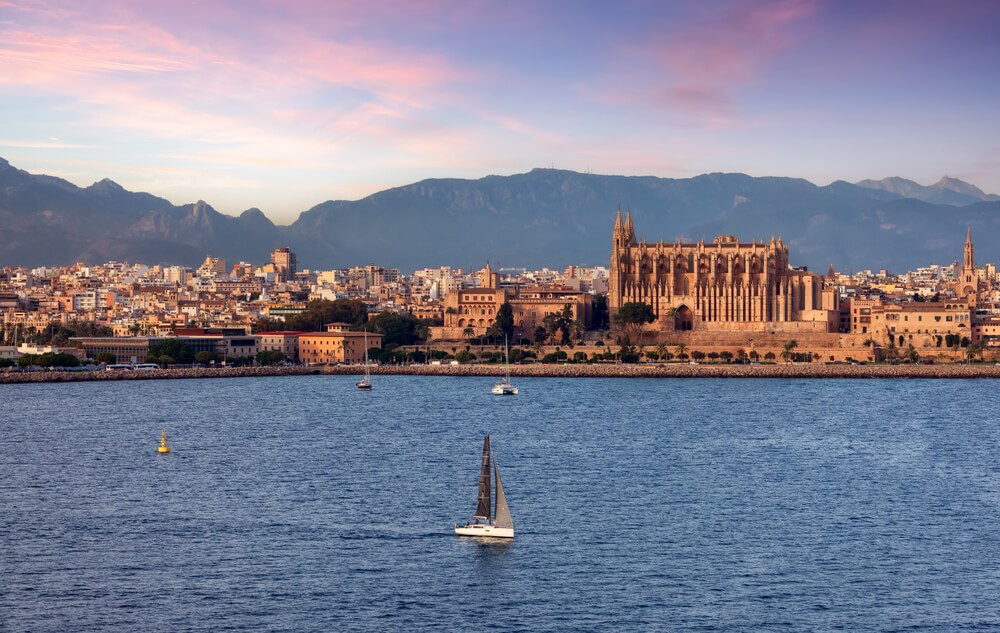 Boat trips in Mallorca: A sailing boat on the water with Palma in the background