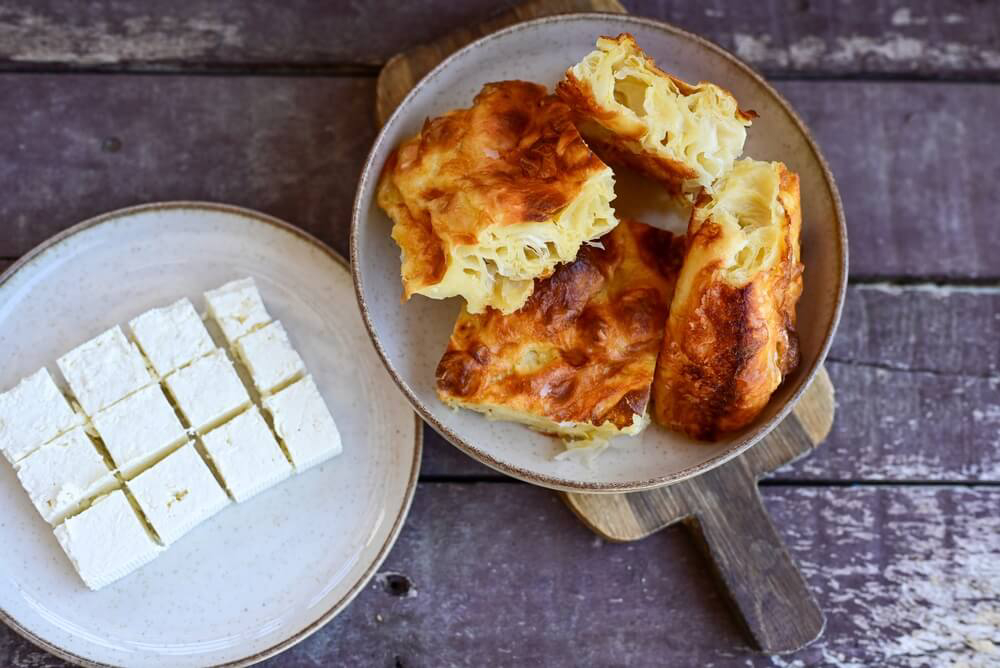 A plate of banitsa pastries with a side dish of Bulgarian cheese