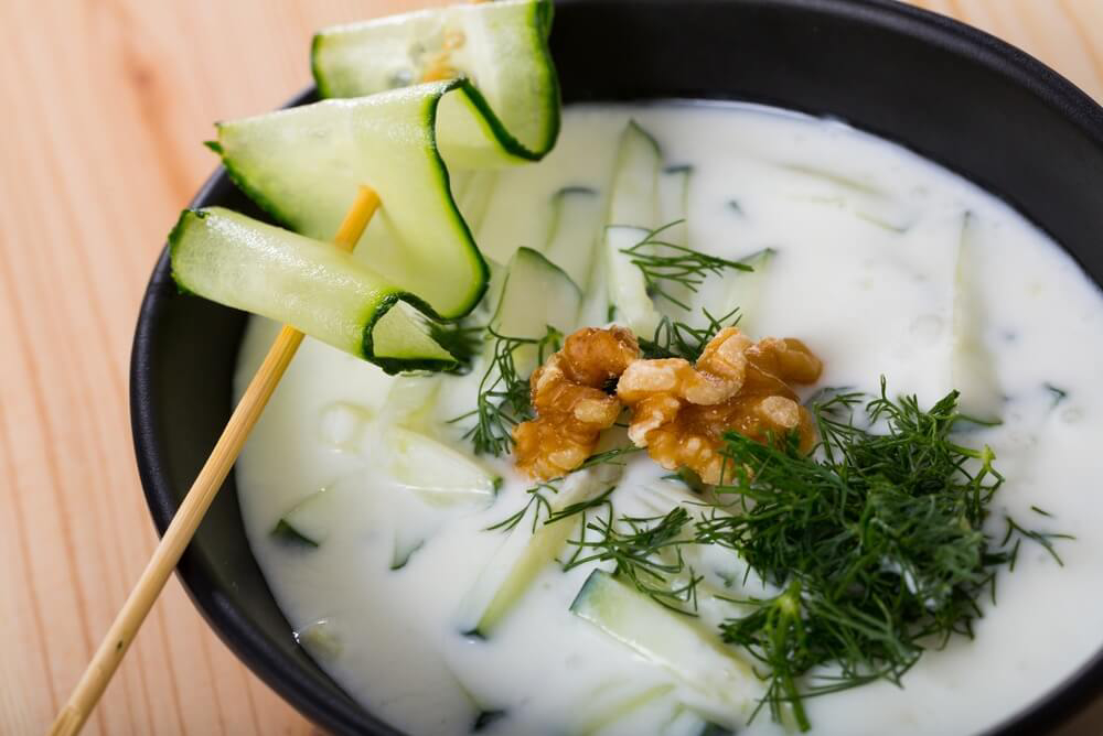 Bulgarian cuisine: a bowl of cold yoghurt and cucumber soup topped with dill and walnuts