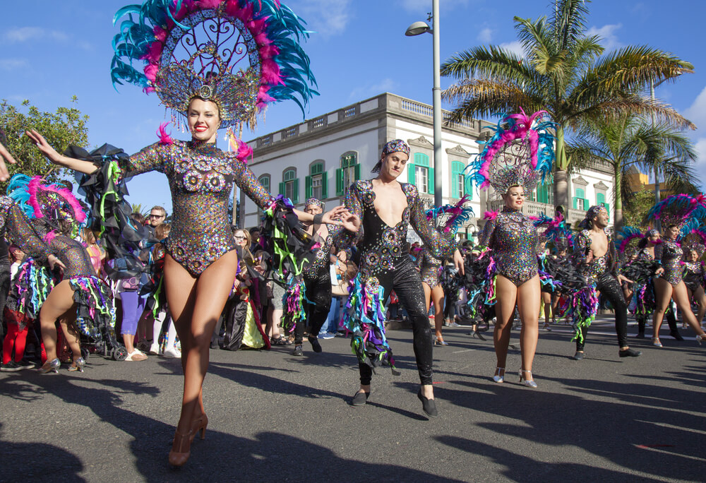 Las Palmas: A group of dancers dressed in black and pink dancing in the street