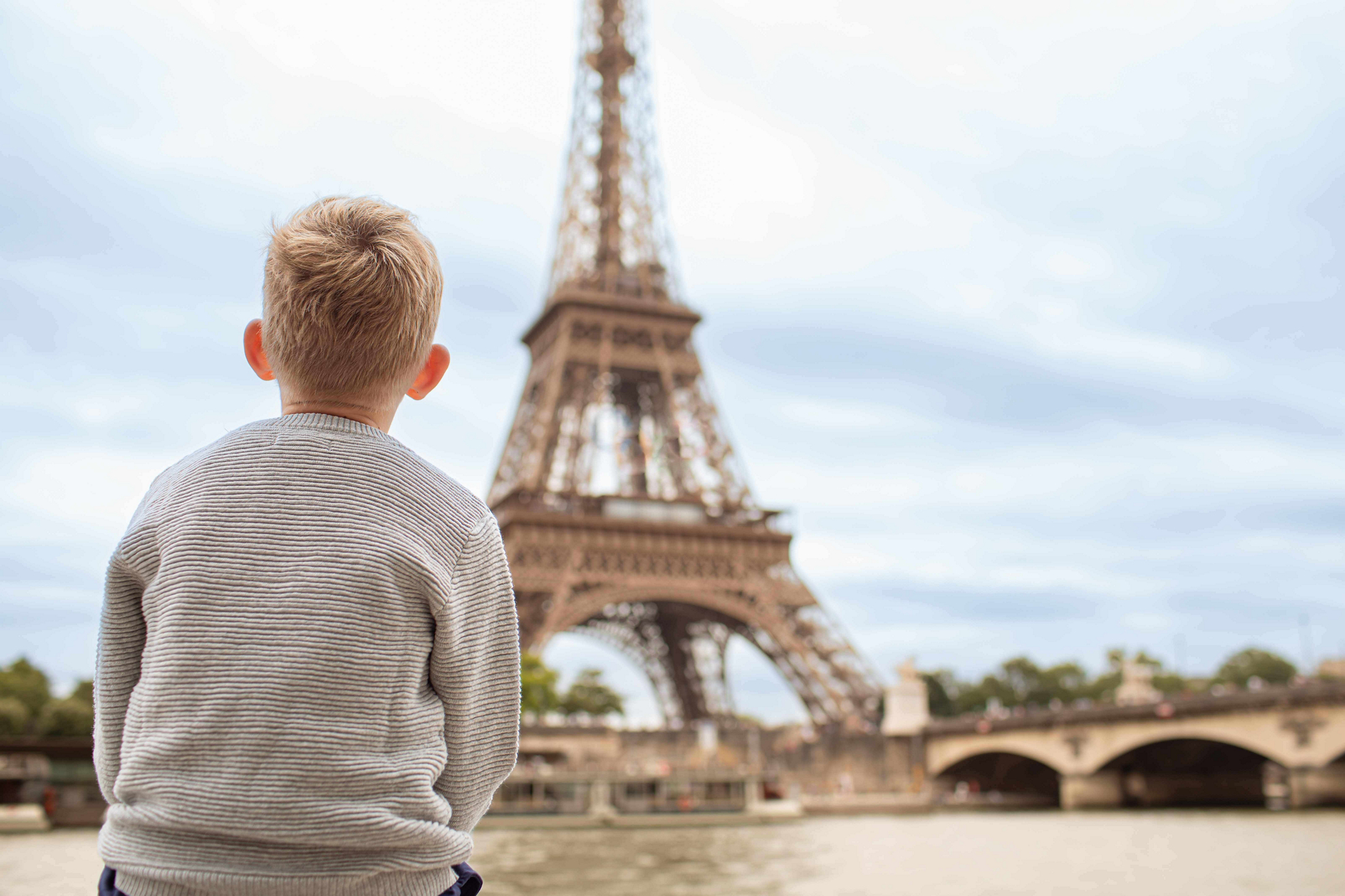 City breaks with kids: a child looks across the Seine to the Eiffel Tower in Paris