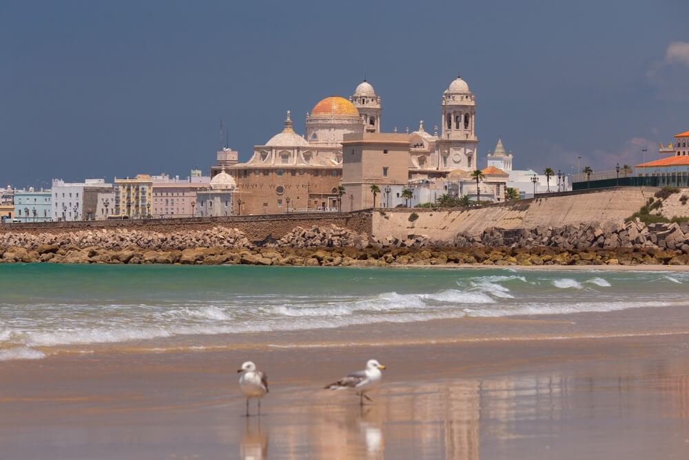 Yellow-domed Cadiz Cathedral from a nearby beach