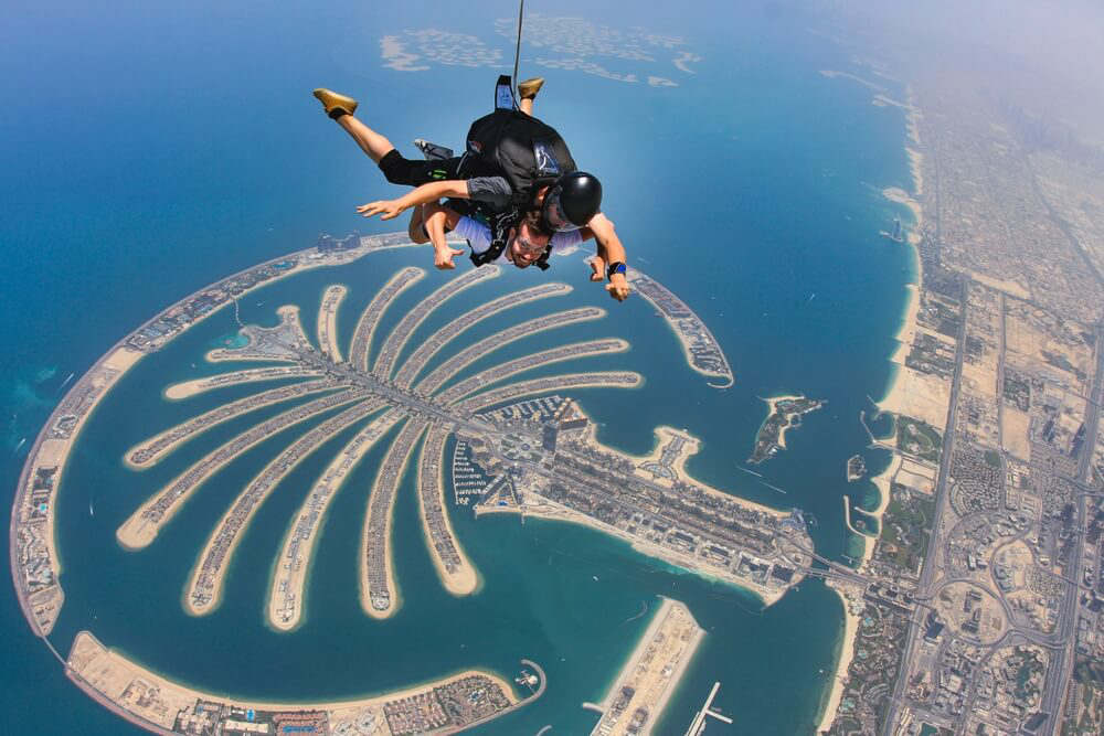 Tandemfallschirmsprung über der Insel Palm Jumeirah in Dubai.