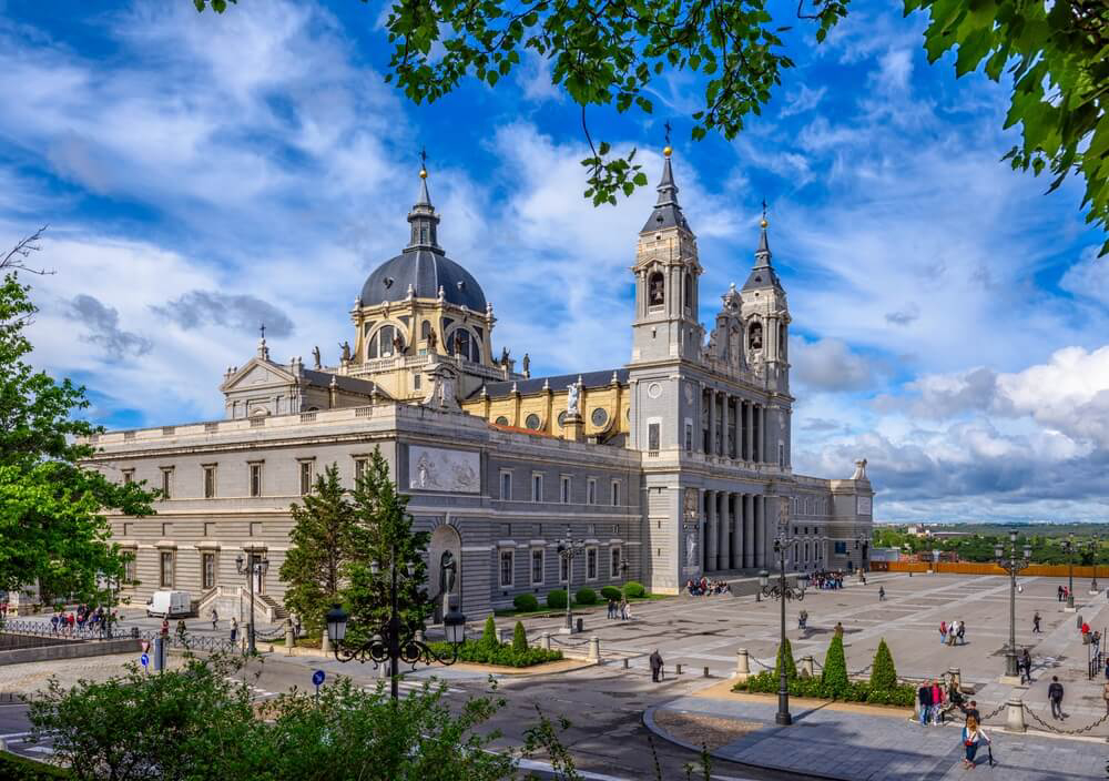 Almudena Cathedral: Large grey turreted building in an open plaza