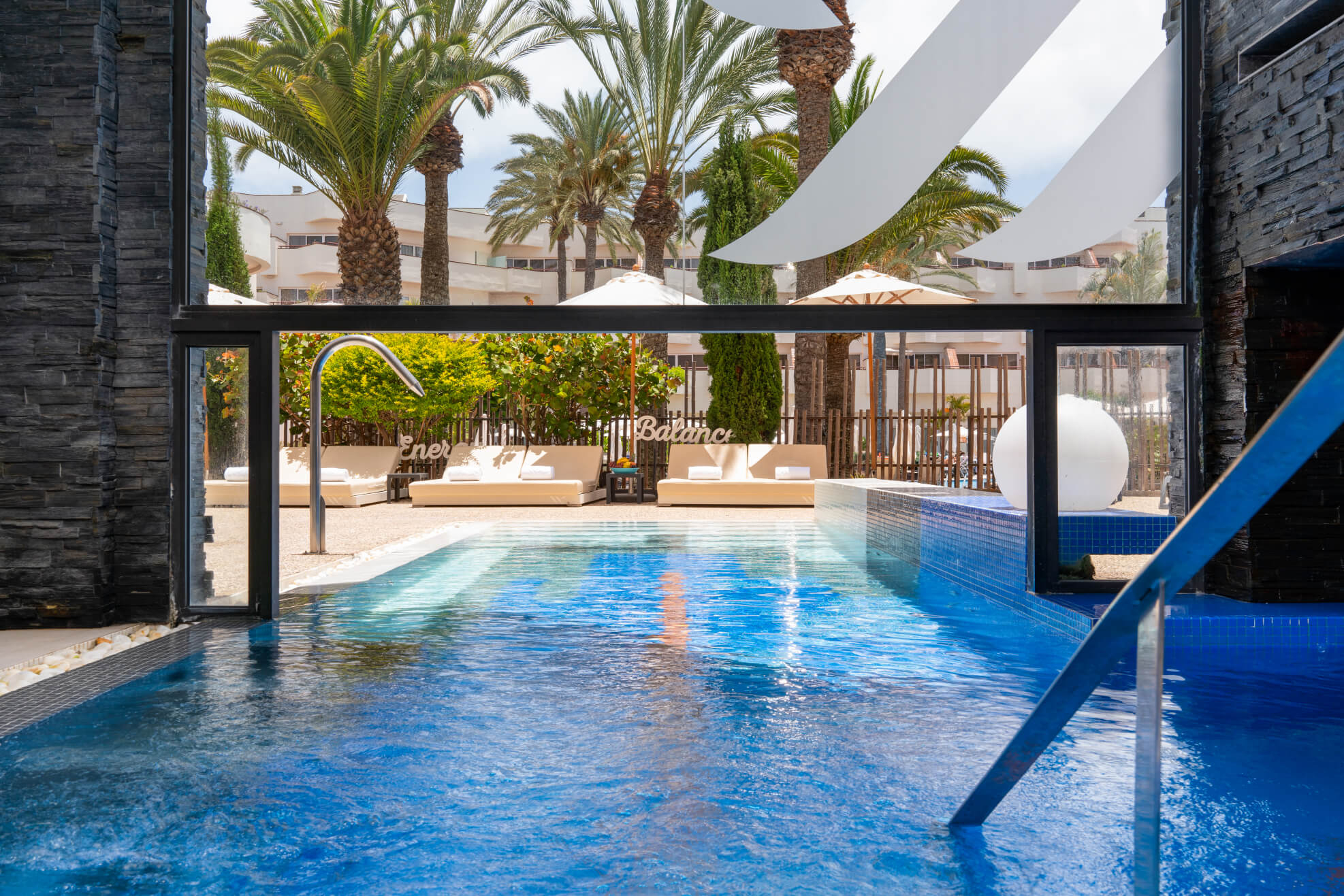 Fuerteventura for couples: a swimming pool leading to shaded loungers and palm trees