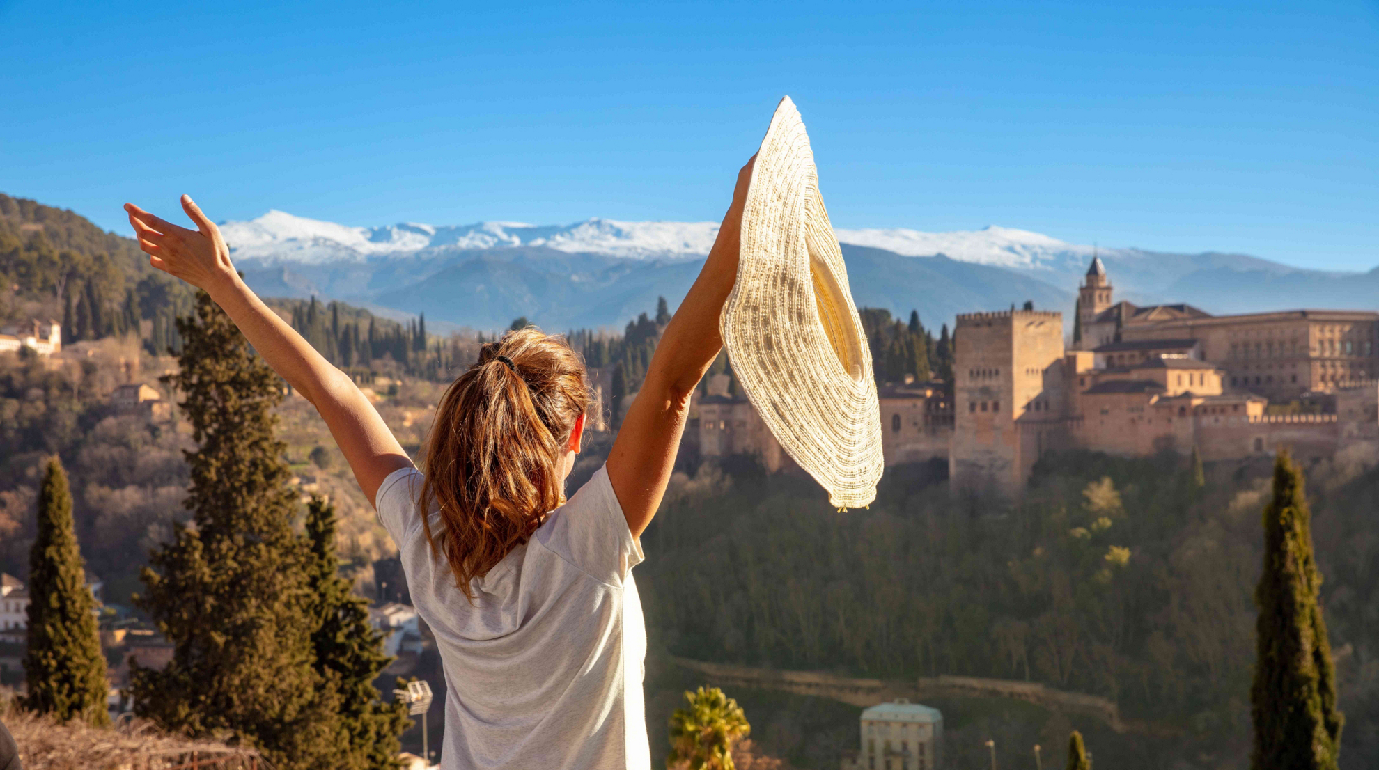 Best holidays for teenagers: Young girl outside with arms outstretched smiling
