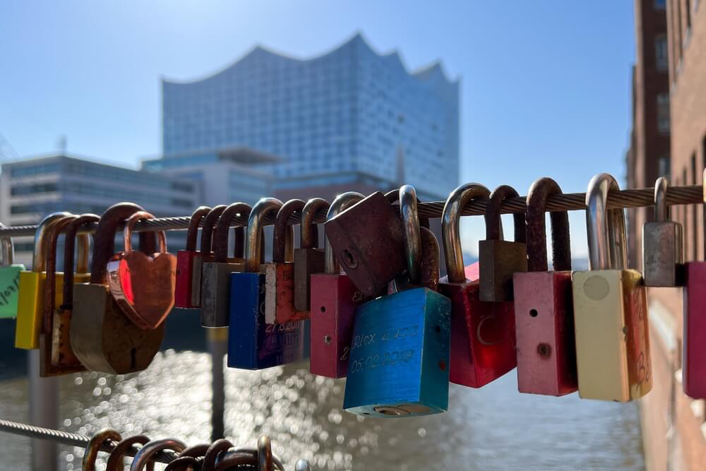 Vorhängeschlösser an einer Brücke in Hamburg mit der Elbphilharmonie im Hintergrund
