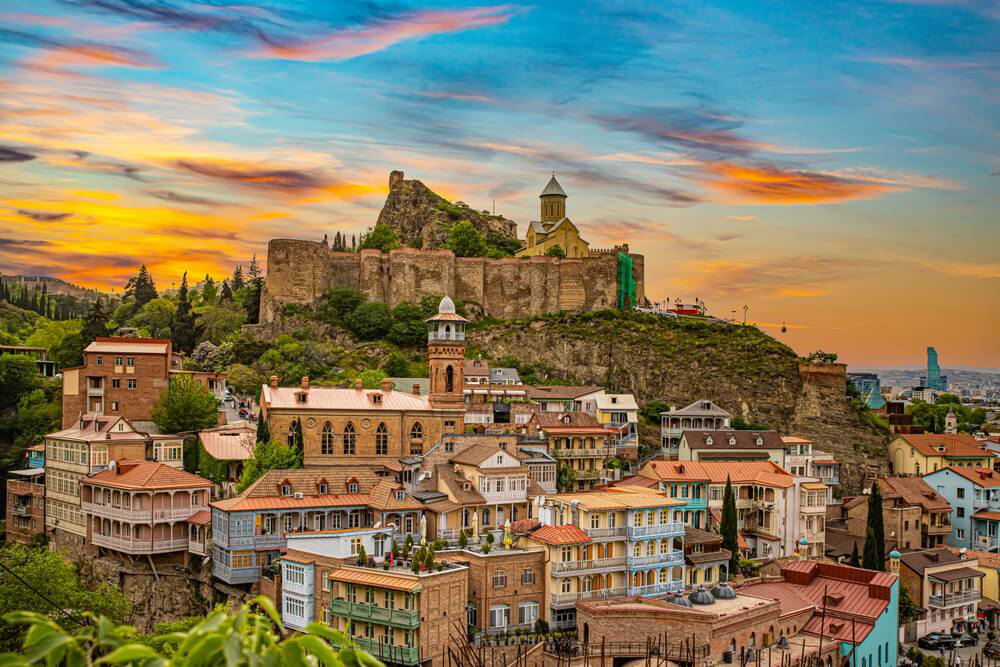 Fortress: Sunset over the hills with a fort on top of them