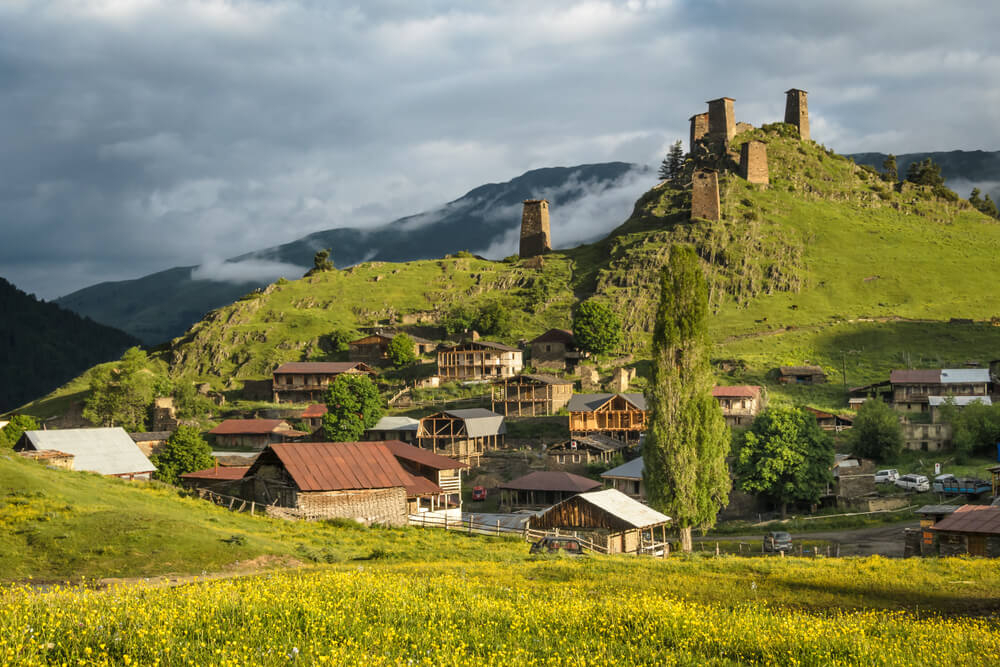 Tusheti: A green hillside dotted with red brick buildings 