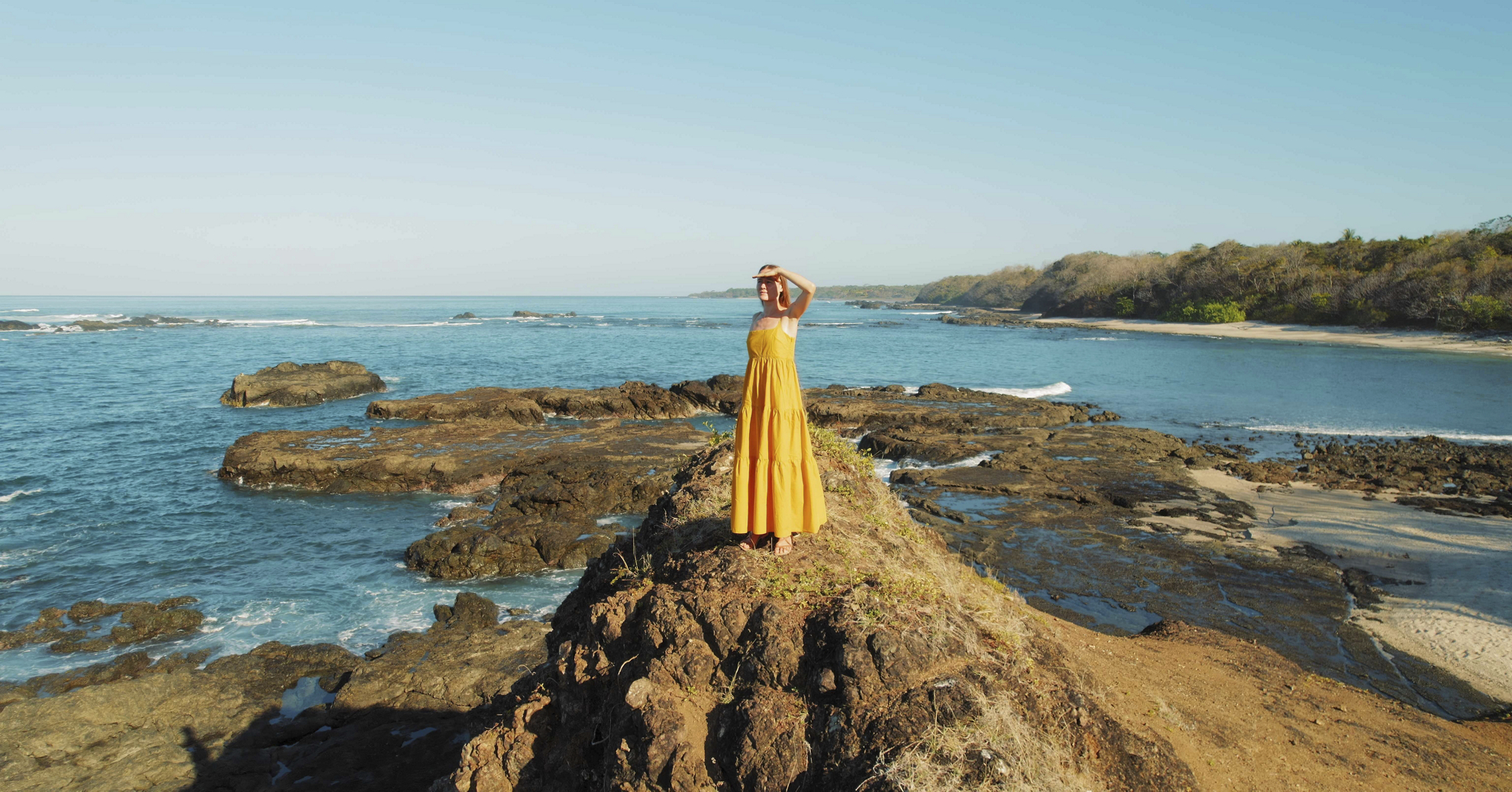 A woman stands on the seaside during her hushpitality trip