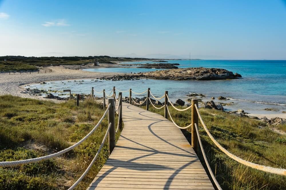 Holzsteg zu einem Strand am Isthmus von Es Trucadors auf der Baleareninsel Formentera