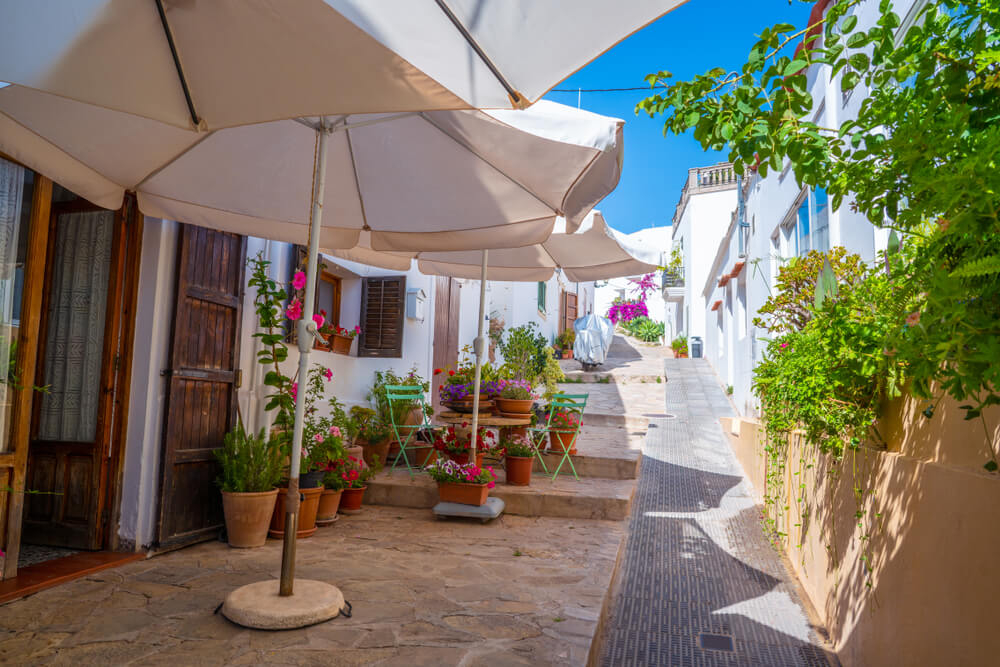 Pittoreske Gasse mit weißen Häuserfassaden im Dorf San Juan Bautista auf Ibiza