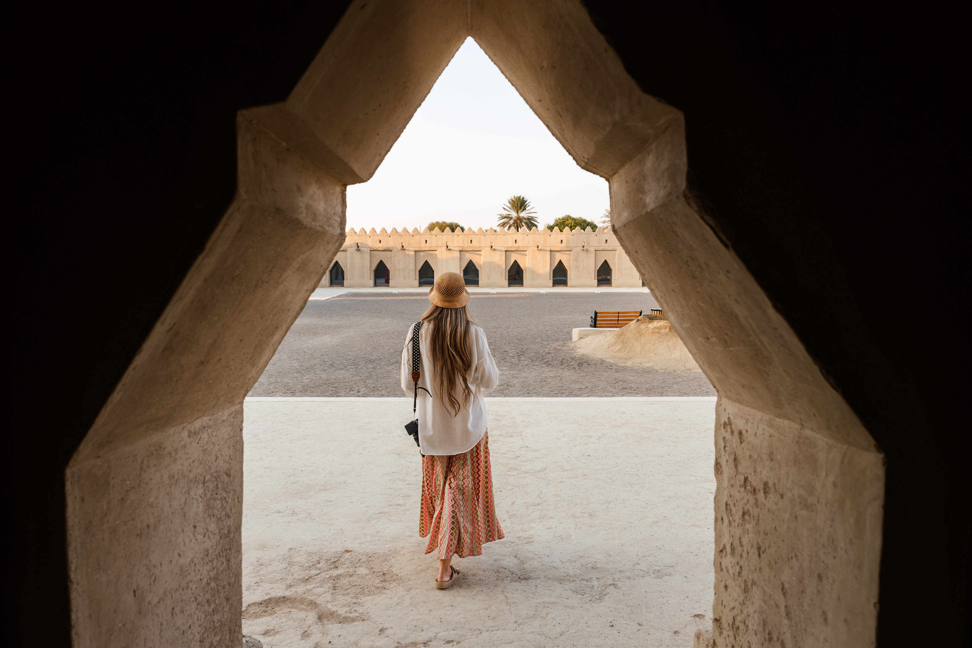 Touristin in Dubai mit bedeckter Kleidung und Hut.