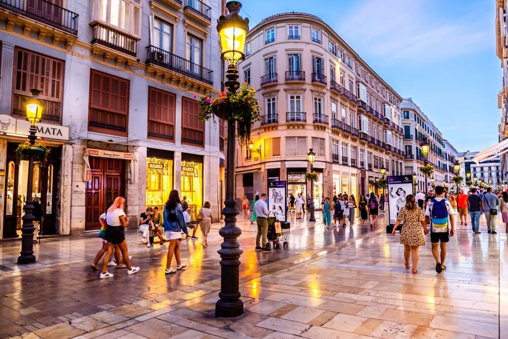 Die Einkaufsstraße Calle Larios in Málaga bei Einbruch der Dämmerung.