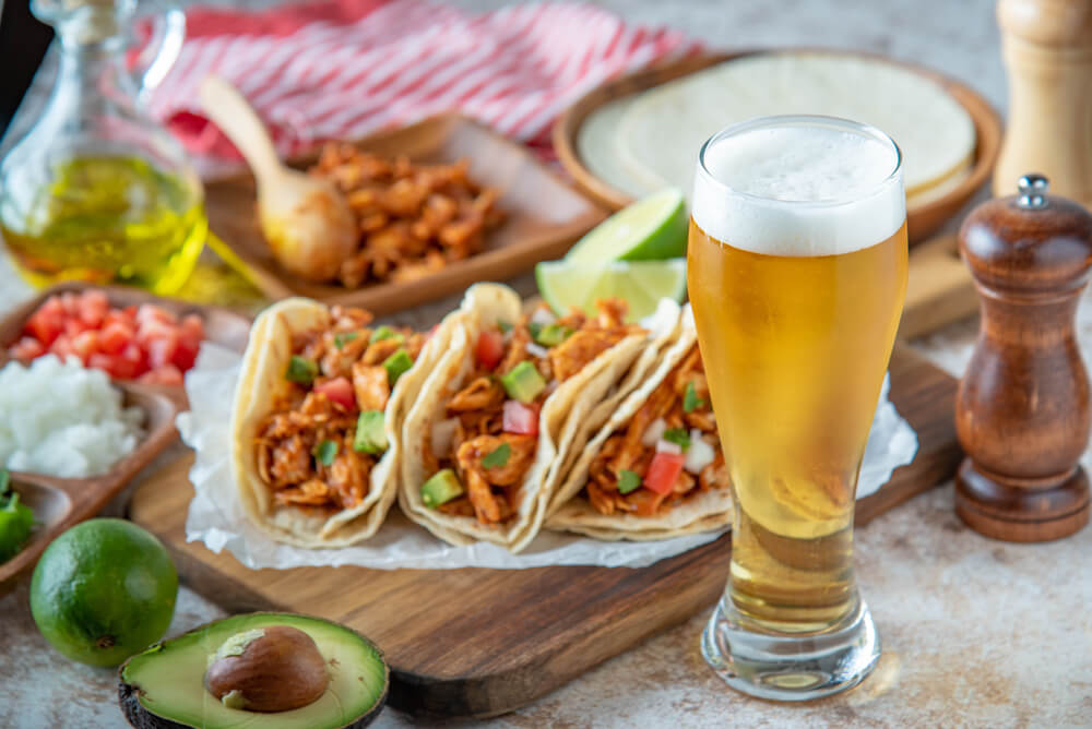 Großes Bierglas neben mexikanischen Tacos.