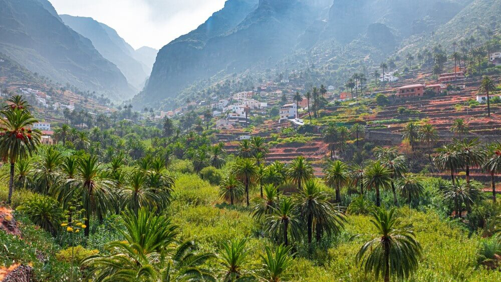Steep mountains tower over a verdant terraced valley in La Gomera