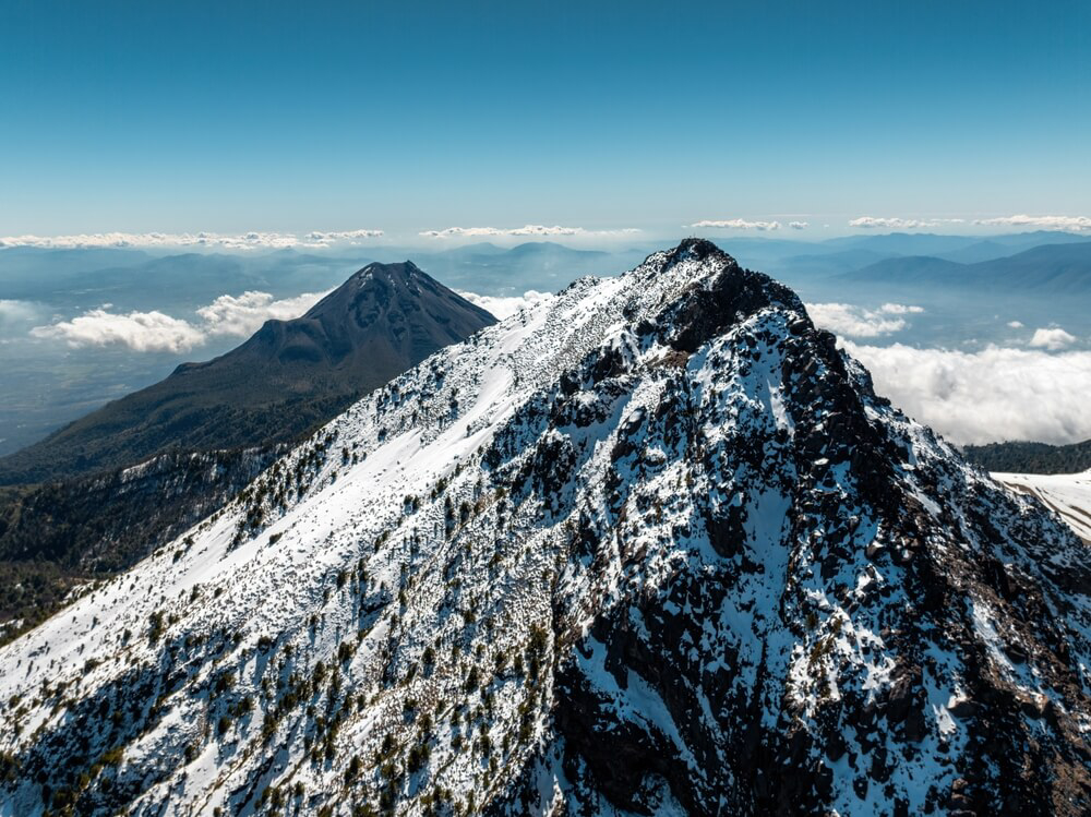         Mit Schnee bedeckter Vulkan Nevado de Colima und sein Nachbargipfel in Mexiko