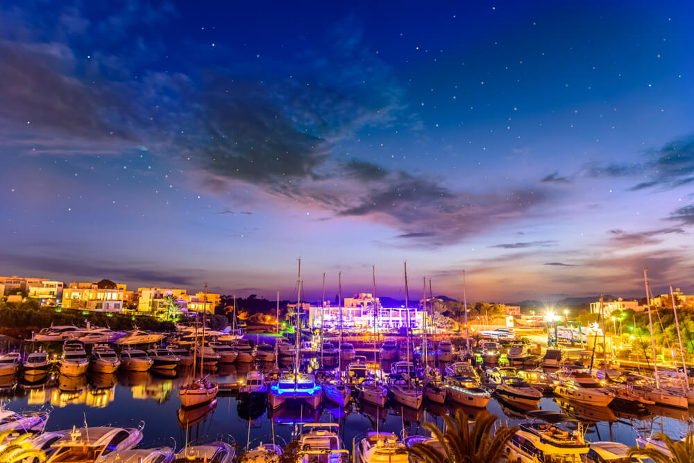 Yachts resting under the stars in a night-time view of the marina in Cala d’Or