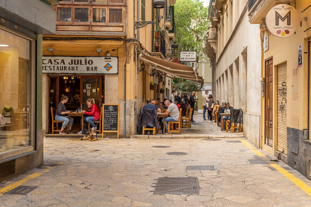 Nightlife in Mallorca: patrons sit at a corner bar in the narrow streets of Palma old town