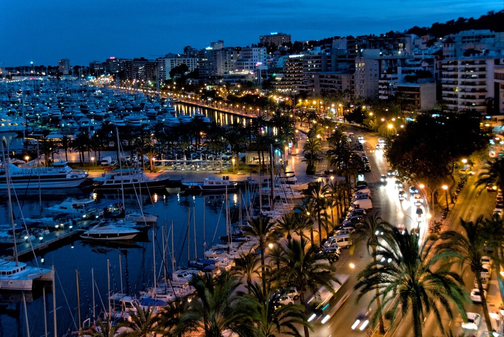 Nightlife in Mallorca: Palma seafront promenade at night with yachts moored at the marina