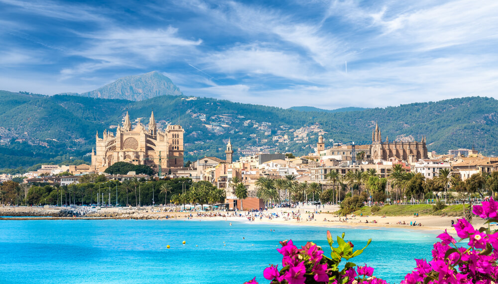 Nightlife in Mallorca: Palma Cathedral and old town between a blue sea and green hills