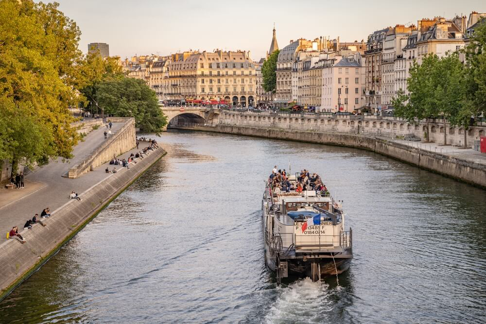 Ein Ausflugsboot auf der Seine in Paris im Nachmittagslicht.