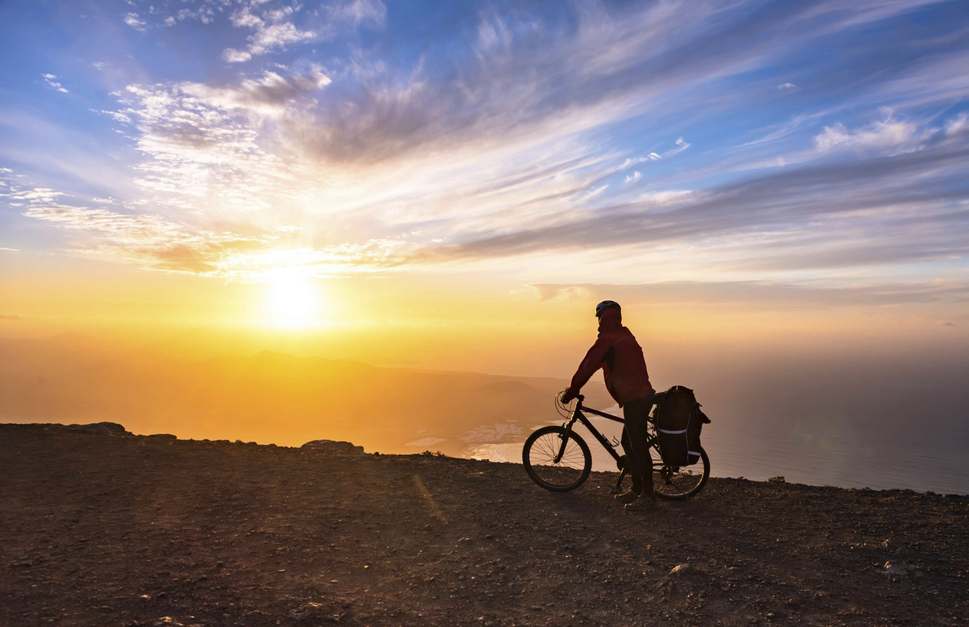 Radfahren auf Lanzarote: Radfahrer auf einer Klippe bei Sonnenuntergang