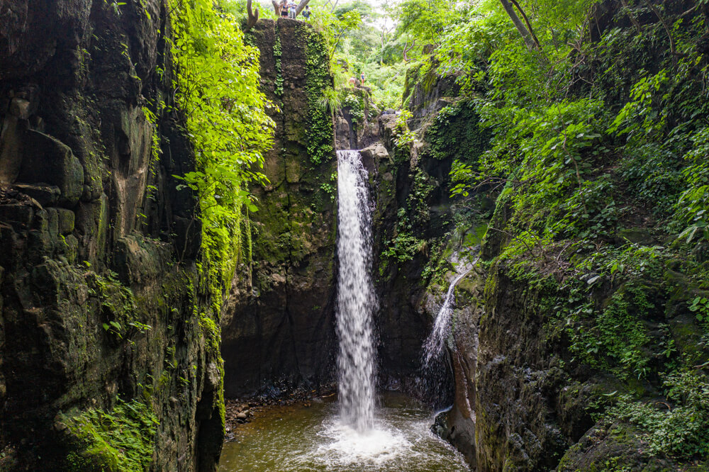 Wasserfall umgeben von grüner Vegetation in Tamanique, El Salvador.