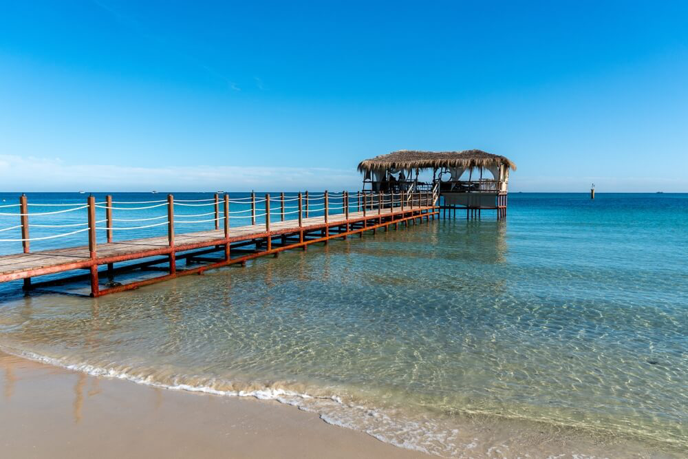 An overwater platform lapped by a calm, crystal-clear sea on Sousse beach