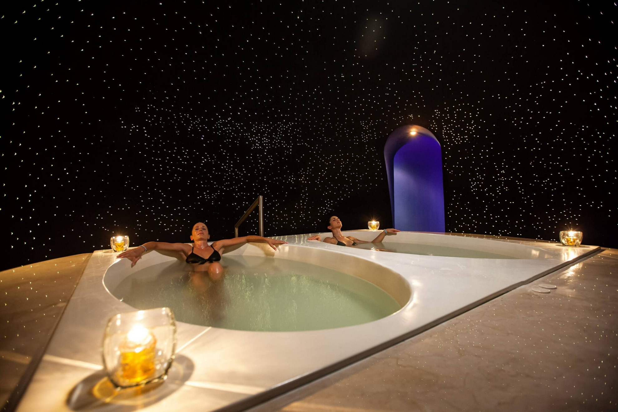 A couple floats in a pool on their spa honeymoon
