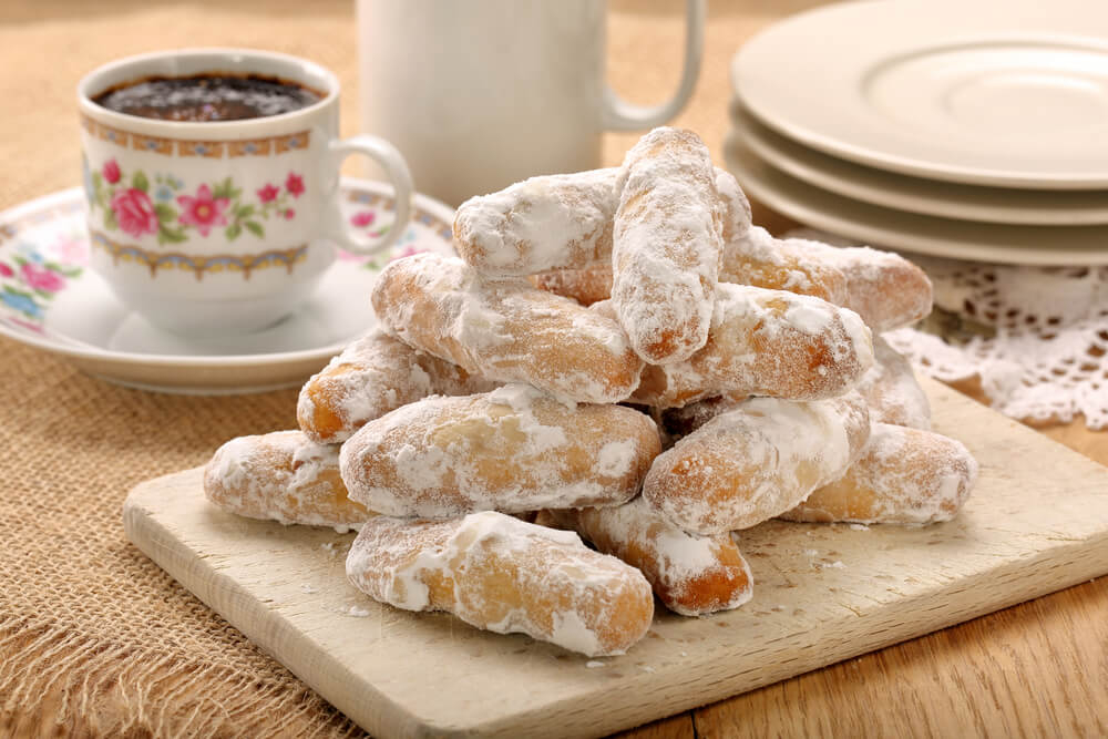 Spanish Christmas Sweets: A wooden board with sugar-dusted sweets and a mug of coffee