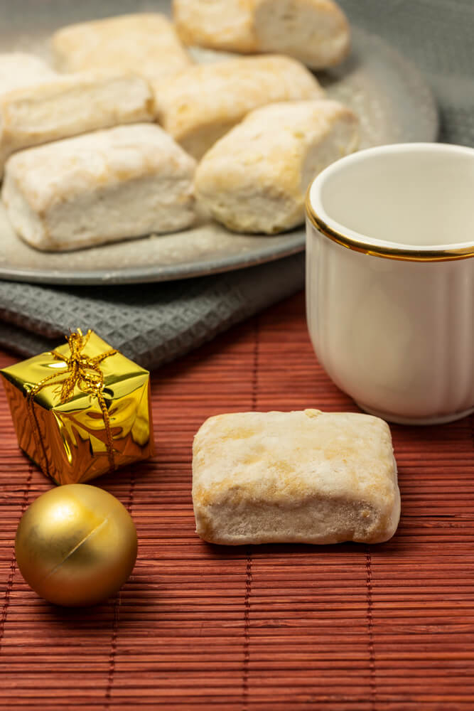 Hojaldrinas: White sugary pastries on a white plate next to a white mug