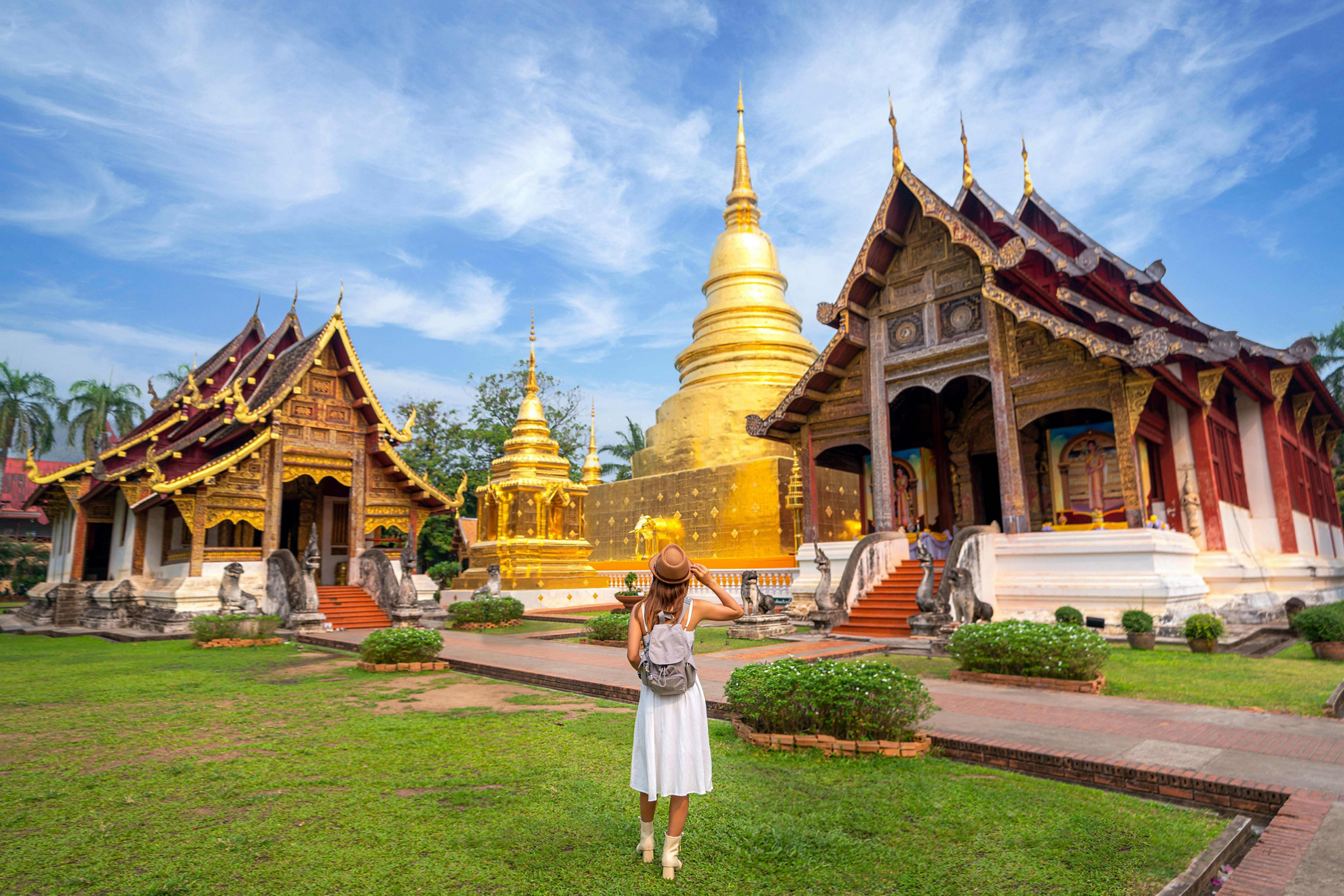 Tempel in Thailand: eine Touristin betrachtet die Pagoden von Wat Phra Singh.