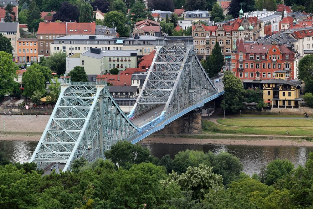 Loschwitz Bridge: A light blue iron bridge with a road that joins both river banks