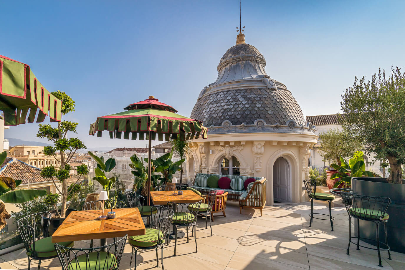 Palacio Gran Vía: A hotel rooftop bar with green tables and chairs