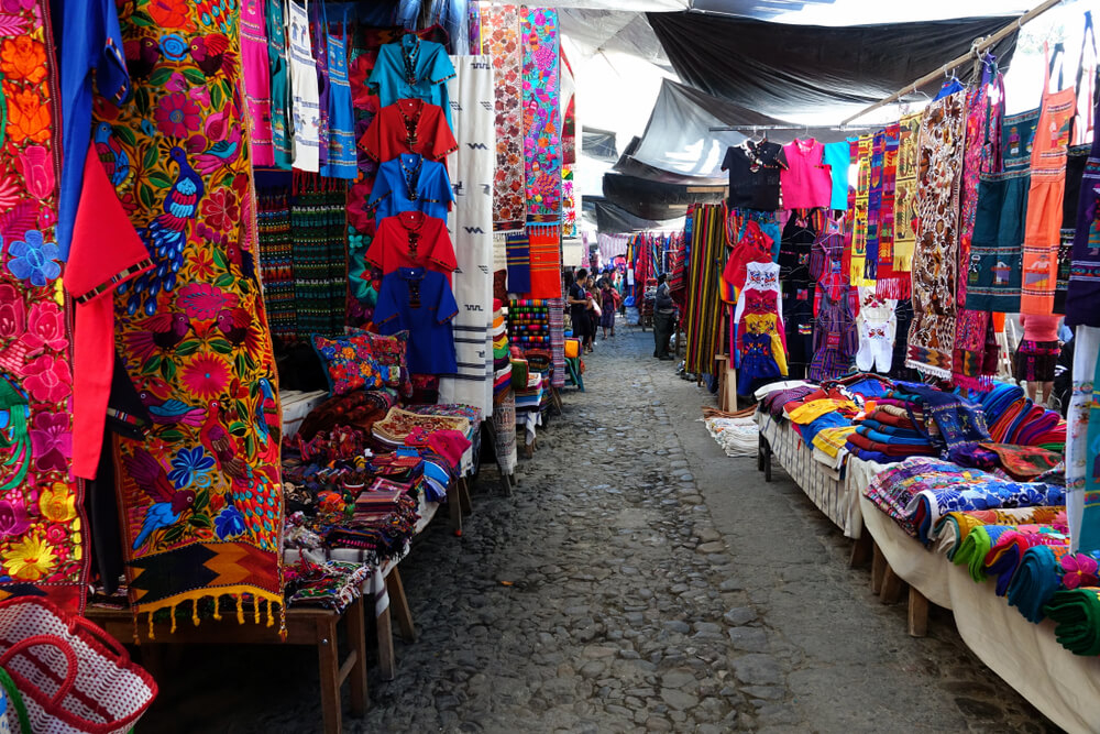 Chichicastenango: Traditional, colorful Mayan textiles hanging at stalls in a market