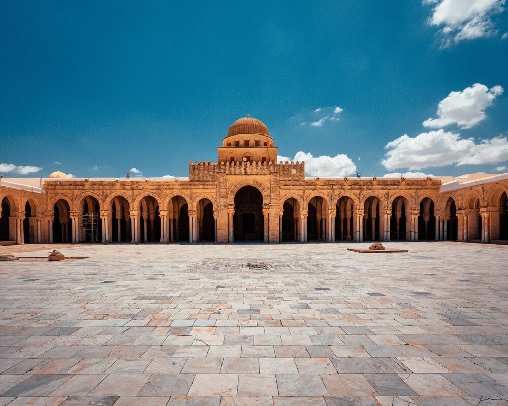 Kairouan: A wide, stone patio with a large mosque in the distance