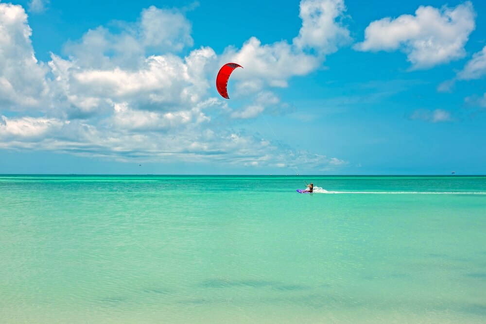 A person kite surfs on Palm Beach, one of many great water activities in Aruba.