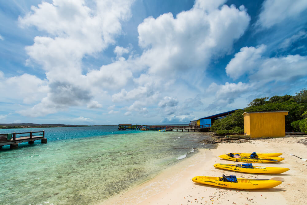 A glass bottom kayak in Aruba sits on the beach.