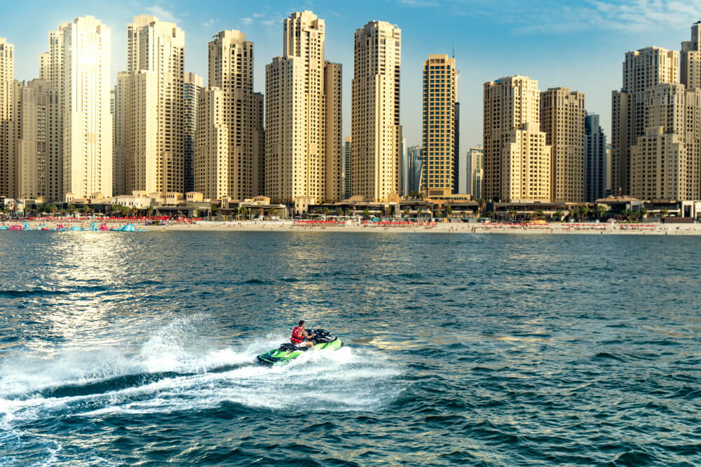 Water sports in Dubai: A jet ski in the ocean in front of the Dubai skyline