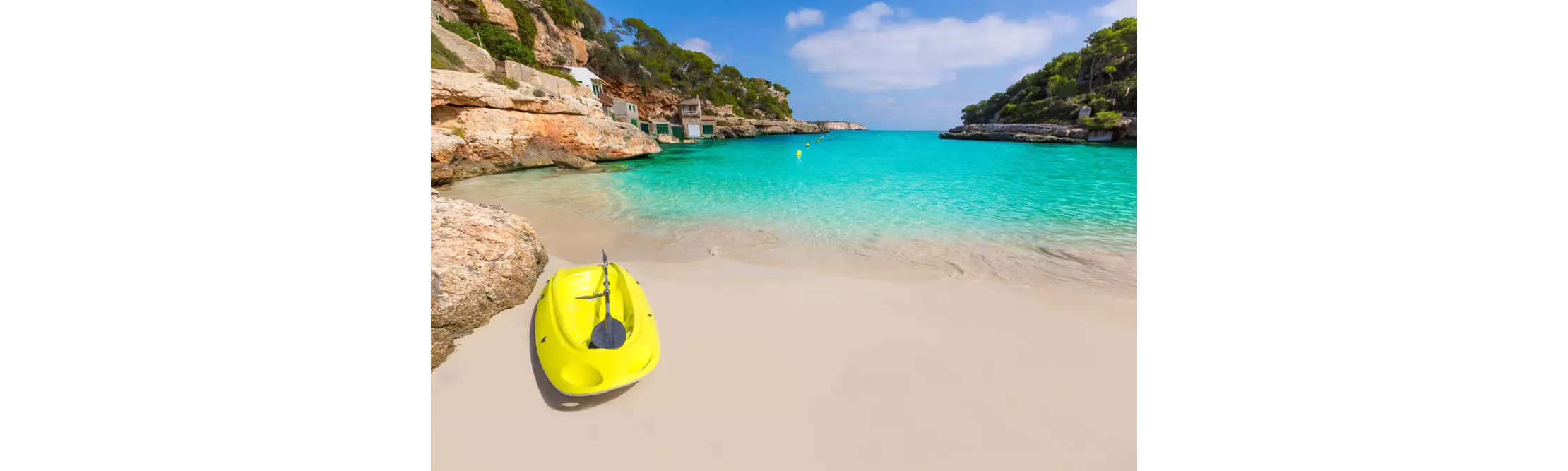 Watersports in Mallorca: Yellow kayak on golden sand with turquoise water in the background